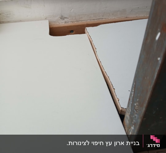 חיתוך והתאמת לוח עץ מותאם אישית סביב קורה במסגרת עבודת נגרות